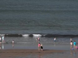 PEOPLE PLAYING IN SEA AND ON BEACH Stock Footage