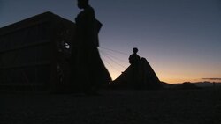 Silhouetted balloonists prepare a hot-air balloon for takeoff against a glowing horizon. Stock Footage