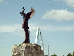 Time lapse "Keeper of the Plains" Native American statue and pedestrian walking bridge, with blue sky and white clouds Stock Footage