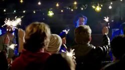 Wide dolly shot of lead guitar through party crowd with sparklers Stock Footage
