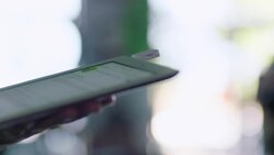 Bike shop cashier swipes woman's credit card on tablet card reader Stock Footage