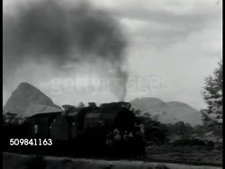 1944: CHINESE EVACUATION: WS Train moving slowly (R) on rural track, possessions piled up on train REVERSE SHOT Train moving (L) filled w/ possessions, belongings.  Japanese Aggression, Refugees, WWII, People's Republic of China. Instructional Video