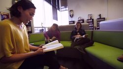 Teacher reading book to students in library Stock Footage