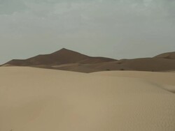 Wide angle shot of desert dunes, partially darkened by clouds. Stock Footage