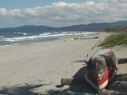 MS, Honduras, Tela, Canoe turned upside down on beach Stock Footage