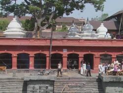 MS ZO People gathering around body of departure while fire stoked to side AUDIO / Kathmandu, Central Region, Nepal Stock Footage