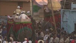 Elephants carry Diwali dignitaries through a huge crowd during a parade in India. Stock Footage