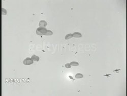 1950: KOREAN WAR: U.S. PARATROOPERS: * MS General Douglas MacArthur sitting in transport plane watching. VS United States 187th Airborne Paratroopers ('Rakkasans') parachuting down, landing on fields in North Korea. 38th Parallel Instructional Video