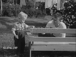 1953: CHILD HELPING FATHER: Boy (3,4) helping father paint hand-made bench outside.  [SOT Dr. Spock saying love your child for whom they are, forget about qualities lacking, will make best of their qualities & opportunities.]... Instructional Video