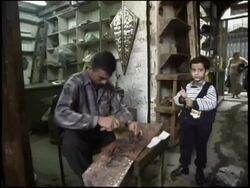 2003 MONTAGE Pre-war Iraq / MS Man pounds metal in workshop with young boy standing by / MS Man kneeling in alley, selling metal goods, tools / Iraq  Stock Footage