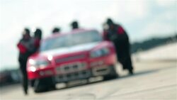 Pit-crew team pushes race-car Stock Footage