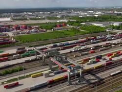WS AERIAL PAN View of container train terminal with cranes, containers and rail tracks / Munich, Bavaria, Germany Stock Footage