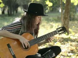 Young woman enjoying playing guitar in the park on summer Stock Footage