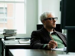 MS R/F businessman seated at workstation in office examining computer monitor and taking notes on notepad Stock Footage