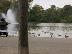 Elderly Man on a powerchair by a lake Stock Footage