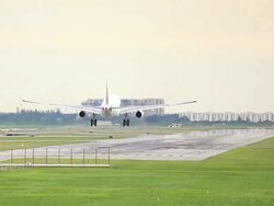 Airplane landing on runway at sunset Stock Footage