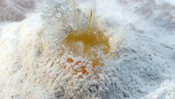 SLO MO LD Dropping the egg into the flour Stock Footage