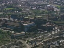 WS AERIAL PAN View of industrial area near river with city / Walloon Region, Belgium Stock Footage