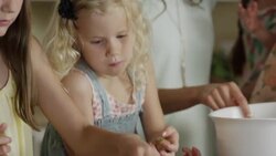 Close up panning shot of mother and daughters rolling cookie dough / Orem, Utah, United States Stock Footage
