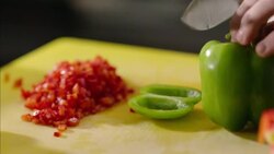 Restaurant chef slices green bell pepper on chopping block in restaurant kitchen Stock Footage