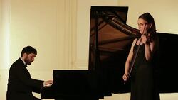 Man and woman performing on piano and violin Stock Footage