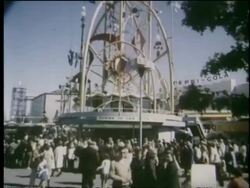 1964 side point of view tilt up of sculpture on top of building surrounded by crowd at NY World's Fair Stock Footage