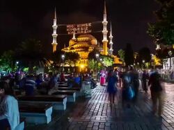 People seated in front of the Blue Mosque during Ramadan at night tilt Stock Footage