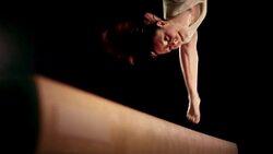 SLO MO Female gymnast doing a flip on the balance beam. Stock Footage