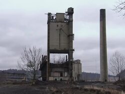 WS Tall building at an old power plant is demolished using explosives and releasing dust  / Weirton, West Virginia, USA Stock Footage