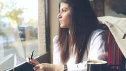Young business woman writing notes while drinking coffee. Stock Footage