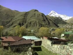 WS PAN Shot of Stepantsminda village located in caucasus mountains / Stepantsminda, Kazbegi, Georgia  Stock Footage