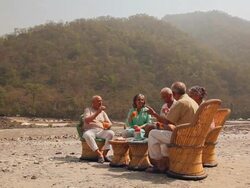 Five senior people drinking juice at riverbank, Ganges River, Rishikesh, Uttarakhand, India Stock Footage