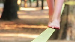 Balancing barefoot on a slackline Stock Footage