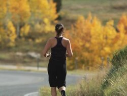 woman running down a mountain road Stock Footage