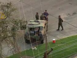 September 12, 2005 aerial medium shot soldiers gathered around humvee at roadblock / Chalmette, Louisiana Stock Footage