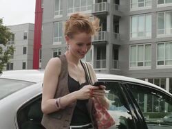 MS Young girl using cellular device outside next to her car on sunny day in urban area / Minneapolis, Minnesota, United States Stock Footage