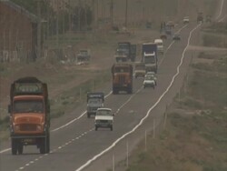 Lorries and cars driving down smoggy country road, Maraghah, Iran(sound available) Stock Footage