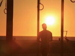 MS SLO MO Man swinging on rings at sunset / Santa Monica, California, United States Stock Footage
