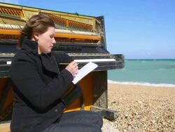 thoughtful young woman writing at the piano Stock Footage