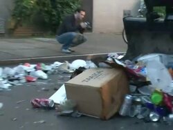 Medium Shot Zoom Out - Garbage truck pushing trash down street / New Orleans Louisiana Stock Footage