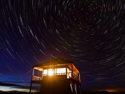 WS T/L Star trails at Werner Peak Lookout Tower while glowing under lantern light at night in Stillwater State Forest / Montana, United States  Stock Footage