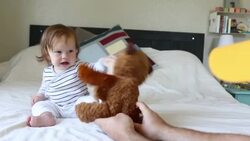 A baby girl laughing and having fun on a bed inside a home. Stock Footage