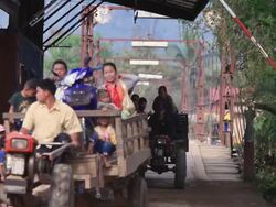 MS Man collecting money from motorcycle and pedestrians after passing bridge /  Vang Vieng, Vientiane, Laos Stock Footage