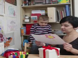 Young boy gives mother a hand made card mother is surprised. Stock Footage