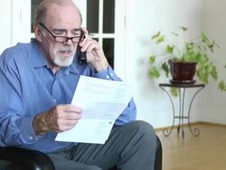 Senior Man Discusses Bills and Documents over Phone Stock Footage