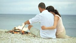PAN Couple hugging and laughing on beach Stock Footage