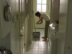 WS, PAN, Woman mopping tile floor in laundry room, Hollywood, California, USA Stock Footage