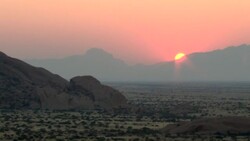 The sun rises behind the Spitzkoppe Mountains in Namibia. Stock Footage
