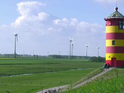 MS People enjoing at Pilsum lighthouse and wind mills near Krummhorn at North Sea (Eastern Friesland) / Lower Saxony Stock Footage