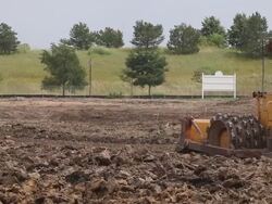 Caterpillar construction vehicle driving through an empty construction site Stock Footage